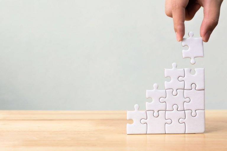 hand-arranging-jigsaw-puzzle-stacking-as-step-stair-wooden-table(2)